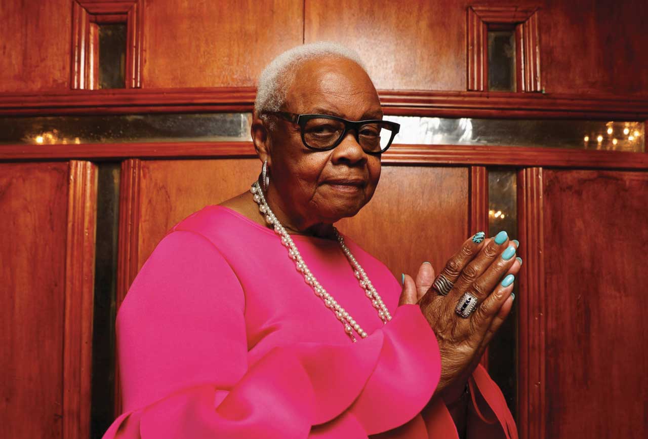 Woman in a pink dress with hands in prayer