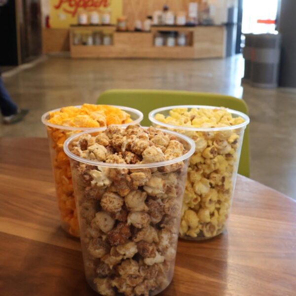 three containers of popcorn on a table