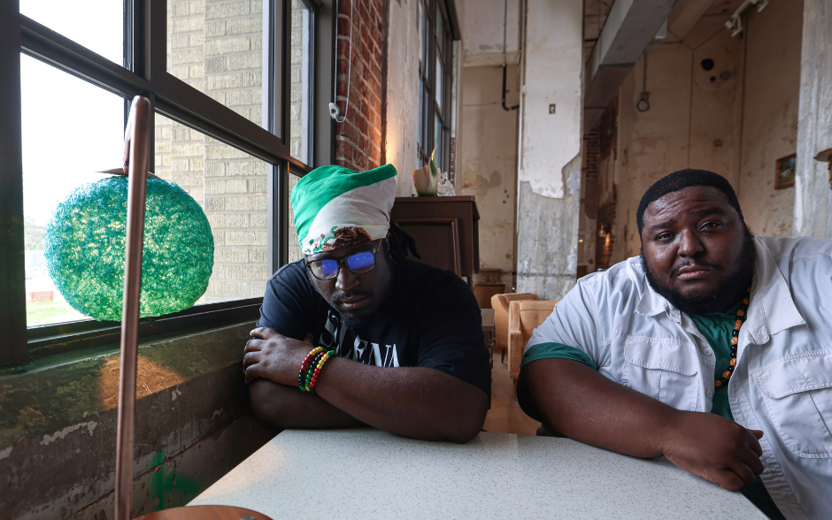 Two men from Memphis reggae band Chinese Connection Dub Embassy sitting at a table