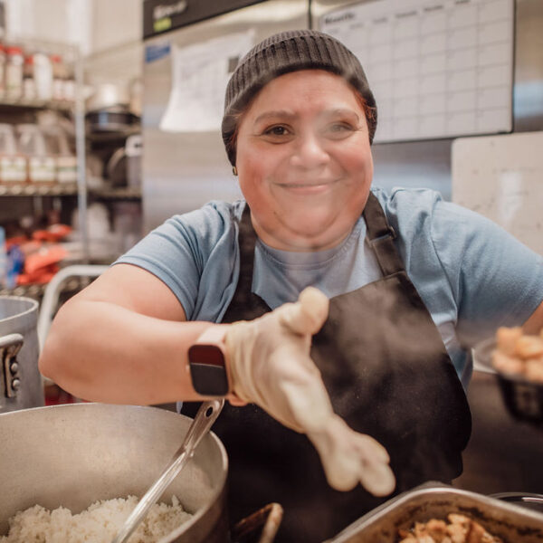 Image of woman smiling in restaurant kitchen