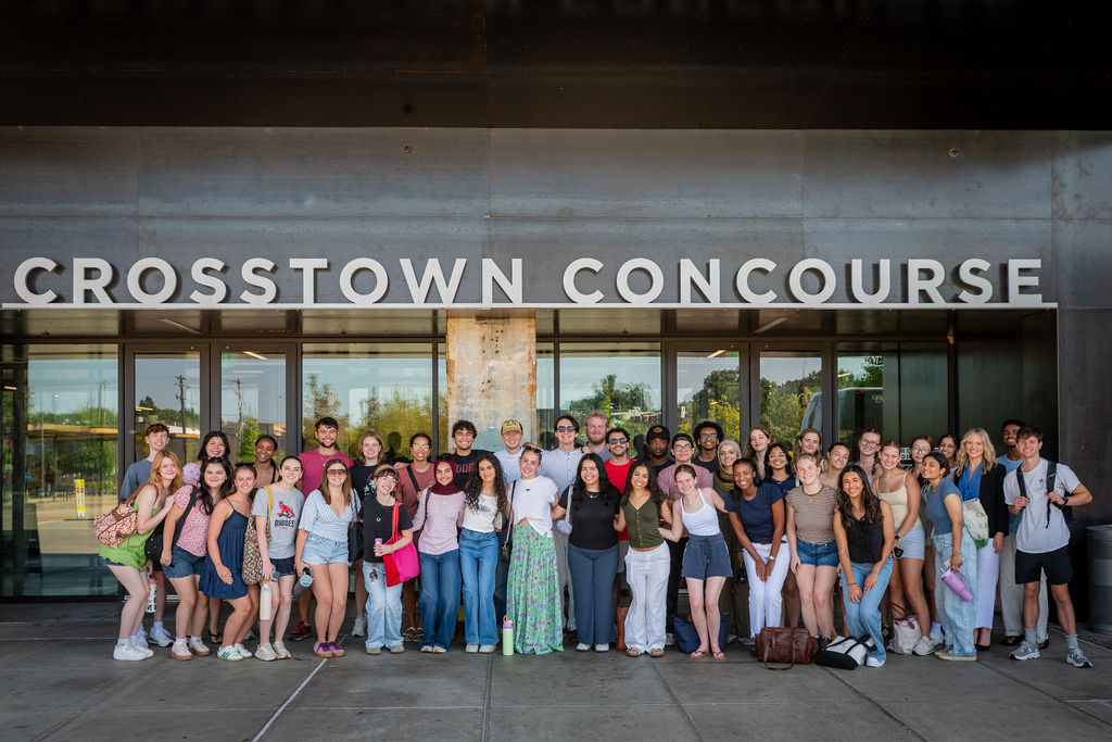 A group of students stand in front of the doors of Crosstown Concourse