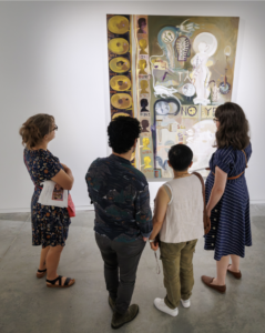 A group of people looking at Barbara Pen's art.